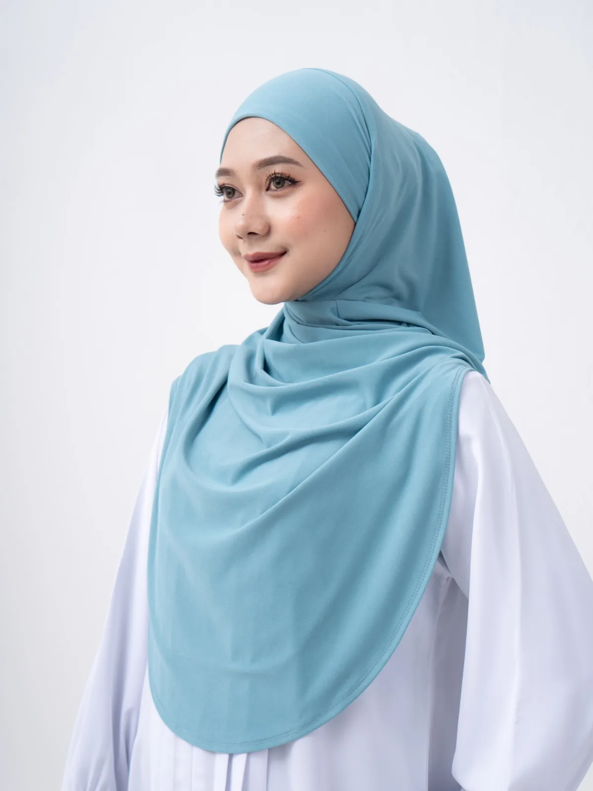 Frau trägt einen SONA Hijab in Türkis zu einem weißen Oberteil